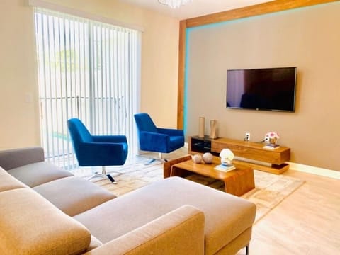 Unwind in your stylish living room with plush seating, modern entertainment, and vibrant blue accent chairs.
