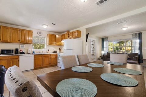 Open-concept kitchen, dining, and living area with a spacious table, full appliances, and plenty of natural light.