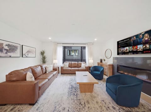 Living Room: Experience sophisticated living. From the sleek fireplace feature to the inviting sofa and fully-equipped kitchen, every detail in this space is curated for your ultimate comfort and enjoyment.