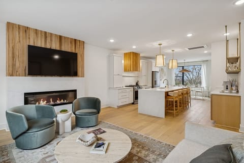 Living Room: Experience sophisticated living. From the sleek fireplace feature to the inviting sofa and fully-equipped kitchen, every detail in this space is curated for your ultimate comfort and enjoyment.