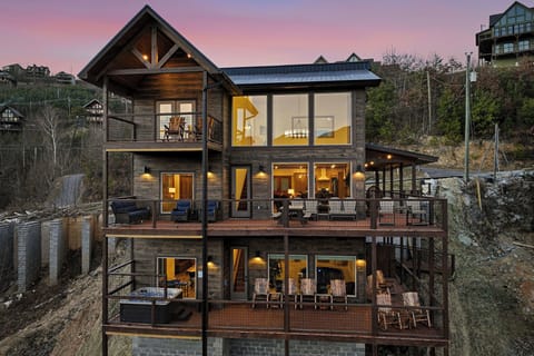 A stunning mountain retreat featuring multiple levels of spacious decks and panoramic views, captured during the magical golden hour.
