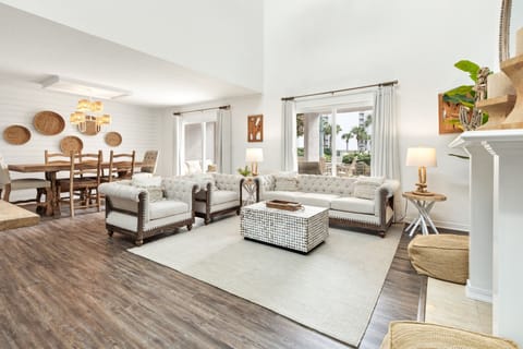 Relax in your bright, open living space featuring cozy tufted seating and natural textures that create the perfect atmosphere for unwinding.