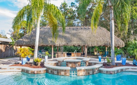 Private backyard pool, spa, and tiki cabana for a tropical escape.
