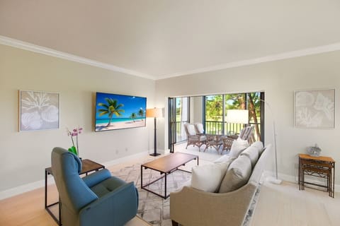 A cozy open-concept living room filled with natural light, comfortable furnishings, and clean, minimal décor.