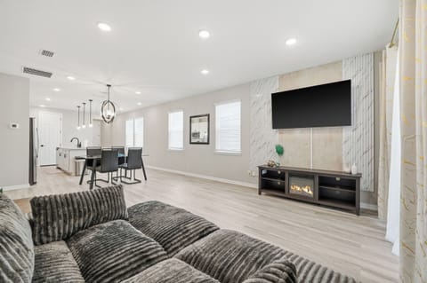 Electric fireplace sits under the huge living room TV