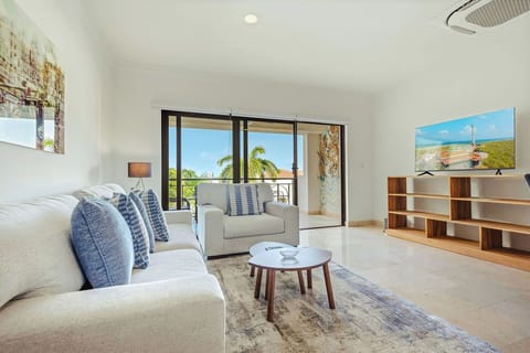 Spacious open-concept living area with cozy seating, a full kitchen, and direct access to the balcony for indoor-outdoor relaxation.