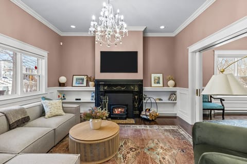 Elegant and inviting living room featuring an ornate fireplace, smart TV, and a plush sectional perfect for relaxing.