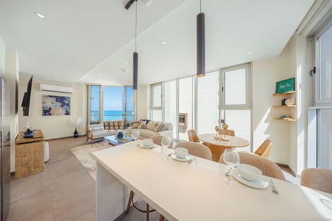 Picture yourself enjoying morning coffee in this stunning open-plan space where natural light pours through floor-to-ceiling windows, framing gorgeous ocean views that stretch across the horizon.