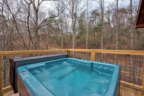 Your private hot tub bubbles away on the deck, surrounded by peaceful woods for ultimate relaxation.
