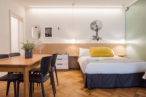 Charming studio with a cozy bed and dining area, perfect for a relaxing stay in the heart of the city.