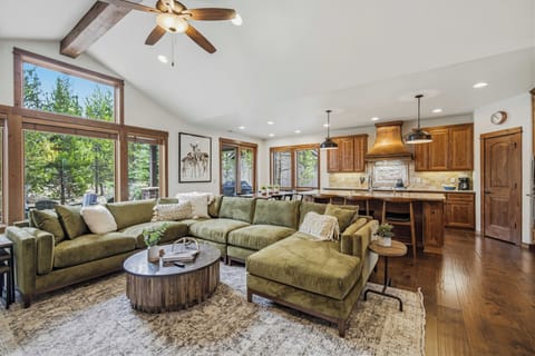 Sink into the plush sectional while sunlight streams through floor-to-ceiling windows, creating your perfect mountain retreat sanctuary.