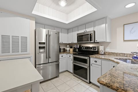 Fully equipped kitchen in this inviting beach stay featuring stainless steel appliances, granite countertops, and bright cabinetry. This vacation rental offers everything you need for easy meals during your laid-back seaside getaway.