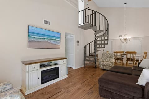 Charming beach stay featuring a stylish spiral staircase, open-concept living and dining area, and cozy fireplace. This inviting vacation rental blends coastal décor and comfort for a relaxing seaside getaway.