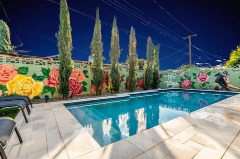 Evening pool views with illuminated rose murals creating a relaxing atmosphere.