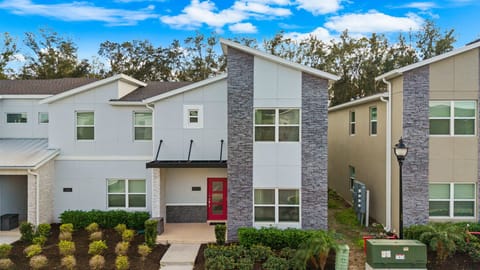 Modern curb appeal: stone accents and a bold red door welcome you home to this stylish Storey Lake retreat.