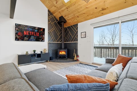 Cozy up by the roaring wood-burning stove! Relax on our spacious sectional sofa and stream your favorite movies on the large wall-mounted smart TV. Features beautiful vaulted wood ceilings and large glass doors to a scenic snowy balcony.