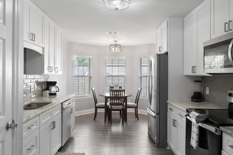 Just steps away, enjoy your morning coffee or a casual bite in the bright breakfast nook, perfectly framed by three large windows that bring the sunshine in.