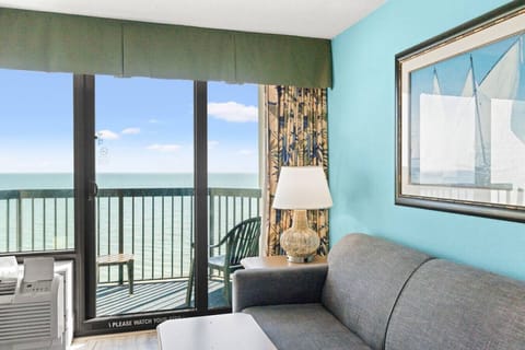 Bright, energizing living room with direct oceanfront views and floor-to-ceiling windows. Natural light fills the space, creating an open, coastal atmosphere perfect for relaxing while overlooking the Atlantic.