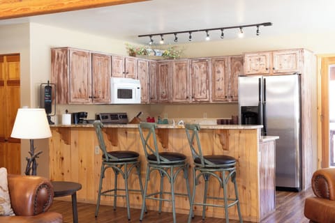 Your spacious kitchen invites culinary adventures with rustic wood cabinets, granite counters, and modern appliances perfectly balanced with cozy mountain charm.