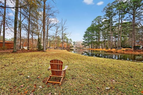 Outdoor seating overlooking the peaceful lake, surrounded by mature trees and open green space—perfect for relaxing or enjoying the view.