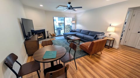 Living room with dining table, wood fireplace and patio with propane BBQ grill