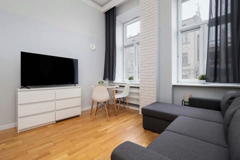 The bright living area with a comfortable sofa and TV invites you to unwind after a day of exploring, while the large window fills the space with natural light and a homely feel.