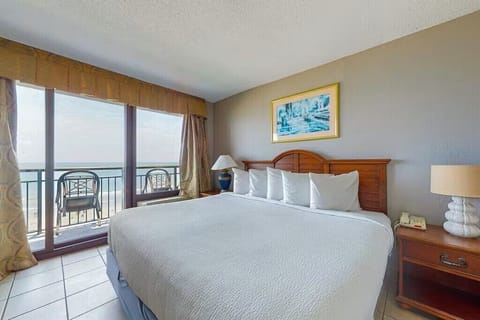 King bedroom with ocean-view balcony and natural light