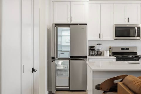 Fully equipped kitchen with full-size refrigerator and generous cabinet storage.