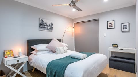 Stylish bedroom with queen bed, soft lighting, and fresh hotel-quality linen