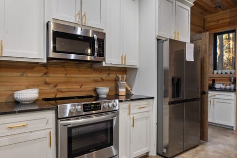 Cook like a pro in our modern kitchen, equipped with high-end stainless appliances and a specialized air fryer for quick, delicious group snacks.