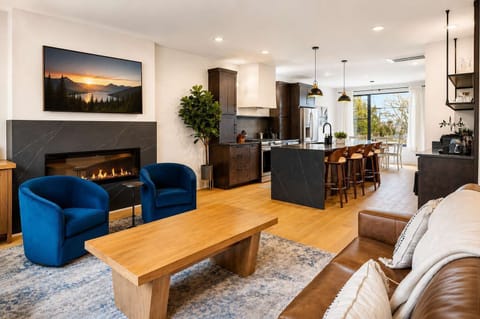 Living Room: Experience sophisticated living. From the sleek fireplace feature to the inviting sofa and fully-equipped kitchen, every detail in this space is curated for your ultimate comfort and enjoyment.
