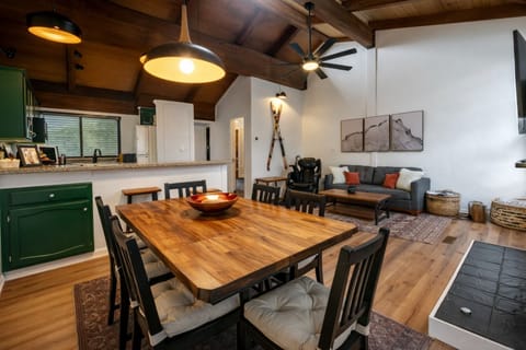 Open-concept cabin living with vaulted ceilings & forest views.