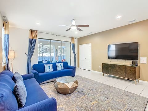 Modern living room with ample seating, flat-screen TV, and natural light