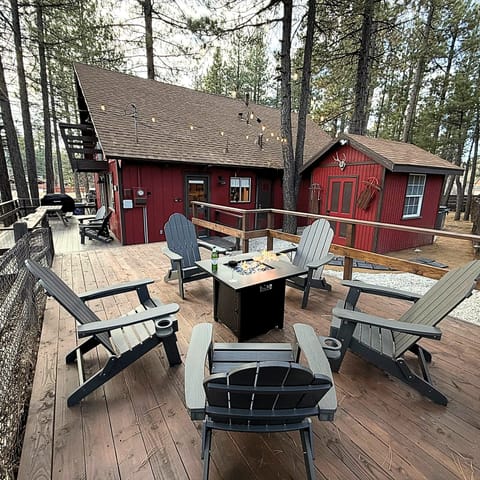 Cozy outdoor gathering space with comfortable chairs, a fire pit, and charming string lights, perfect for relaxing evenings under the stars.