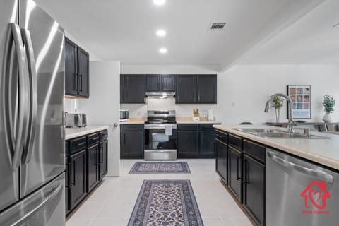 Modern kitchen with stainless steel appliances and dark cabinets.