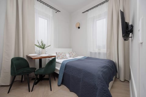 Bright studio interior with a comfortable sleeping area and dining table.