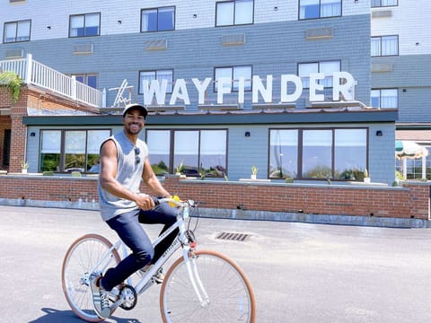 Guest riding a bike in front of the property on a sunny day