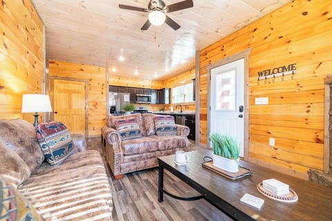 Cozy up in your rustic retreat with warm knotty pine walls, comfy southwestern-style seating, and an open kitchen perfect for mountain getaways.