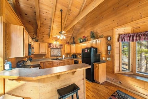 Gather around this warm log cabin kitchen where rustic wood beams frame your culinary adventures and cozy meals together.