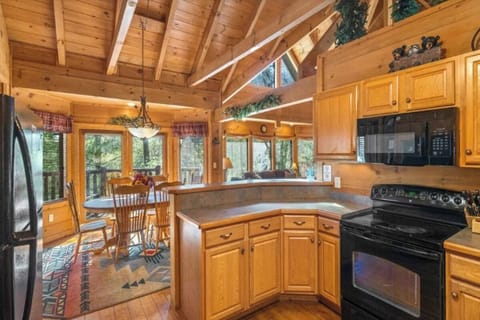 Your fully-equipped kitchen features rustic wood beams, modern appliances, and forest views to inspire your mountain cooking adventures.