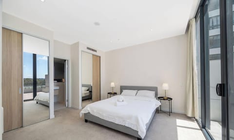 Bedroom featuring a queen-size bed, built-in wardrobe, and balcony access.