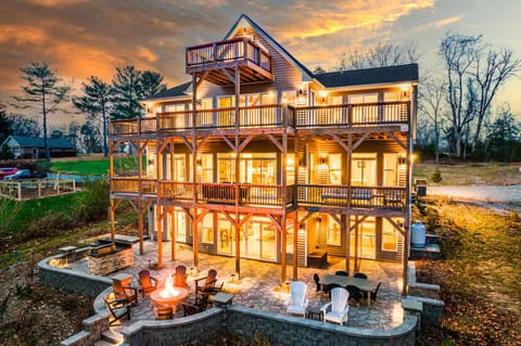Warm evening glow over a cozy retreat with wraparound decks and a fire pit.