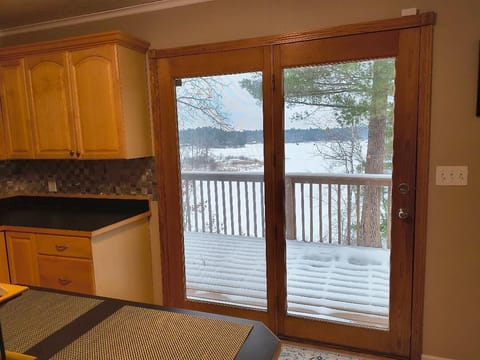 Exit kitchen lakeside to wrap around deck.