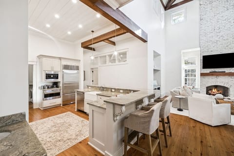 Step into your elegant open-concept retreat where exposed beams frame your gourmet kitchen, perfect for creating memorable meals and cozy evenings by the fireplace.