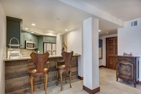 Entertain guests in the open kitchen and bar area, featuring modern appliances, a spacious countertop, and stylish bar seating for a casual dining experience.