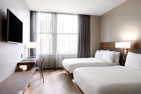 Cozy room with twin beds, large window, and study desk