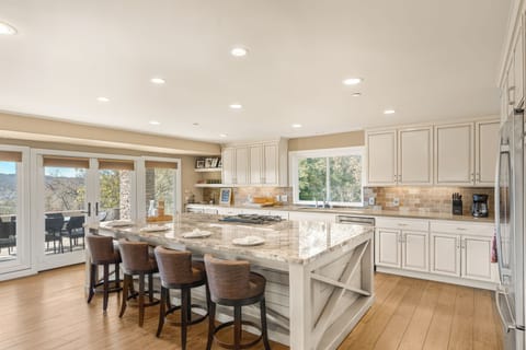 Kitchen featuring a large island with barstool seating and modern appliances.