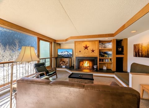 Cozy up by your crackling wood-burning fireplace while enjoying mountain views through floor-to-ceiling windows