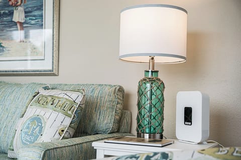 Relax in your coastal-themed living space with soft aqua tones, nautical artwork, and a beautiful glass lamp creating the perfect seaside ambiance.