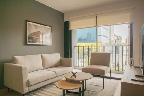 Bright living room with comfy seating and balcony access.